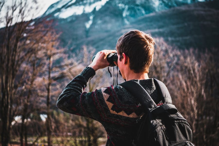 man using binocular for birdwatching